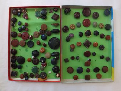 un livre ouvert contenant plusieurs boutons, posé sur une surface blanche