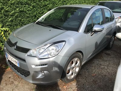 une voiture argentée garée dans un parking à côté d'autres voitures