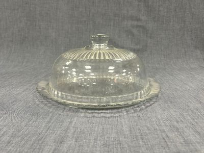un dôme en verre transparent muni d'un couvercle bombé, posé sur une table