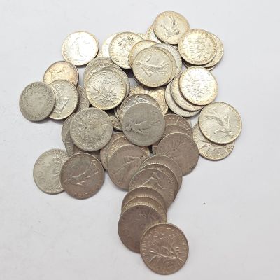 une pile de pièces d'argent sur une surface blanche