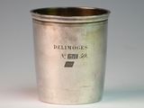 an old silver cup sitting on top of a white table