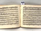 an open book with music notes on it sitting on top of a table