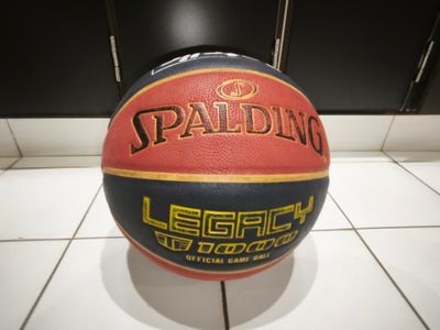 un gros plan d'un ballon de basket posé sur un sol carrelé