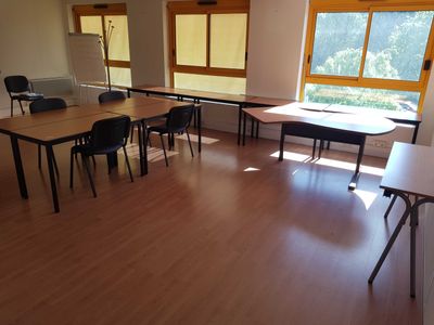 a room with tables and chairs in it and a window in the background