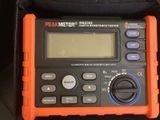 an orange and black digital multimeter sitting on top of a black bag