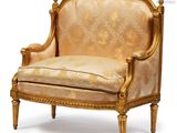 a gold colored chair with a floral pattern on it