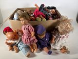 de nombreuses poupées dans une boîte en carton posée sur une surface blanche