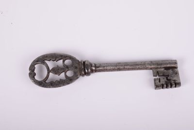 a close up of an old key on a white surface