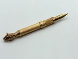 un stylo ancien en laiton orné d'une tête de lion à son extrémité