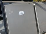 two refrigerators sitting next to each other on the side of the road