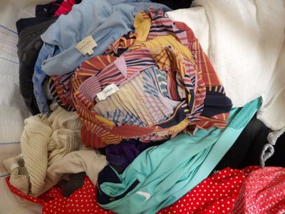 a pile of clothes sitting on top of a bed
