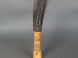 une image représentant un porte-brosse en bois muni d'un long manche