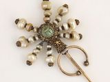 une photo d'une broche ornée de perles et d'une paire de ciseaux