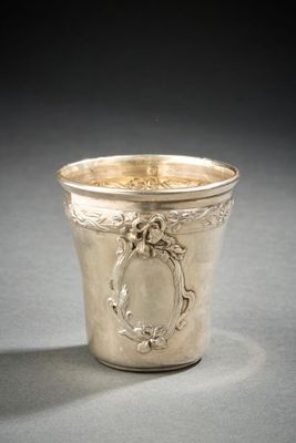 an antique silver cup sitting on top of a table next to a black background
