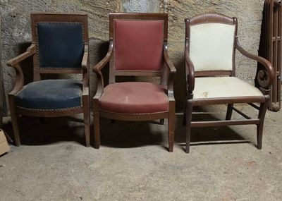 trois chaises placées côte à côte devant un mur en pierre