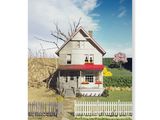 une maison blanche avec un auvent rouge à l'avant