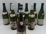 six bouteilles de vin sont alignées sur une surface blanche