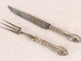 two forks and a knife on a white surface