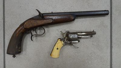 two guns that are on the floor next to each other