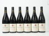 six bouteilles de vin sont alignées sur une surface blanche