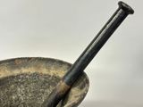 an old mortar and a wooden stick in a bowl