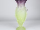 purple and green vase sitting on a white surface with a white background