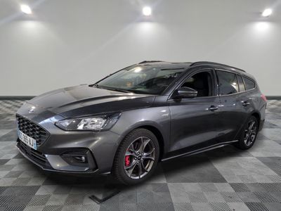 Une Ford Focus grise est garée sur un sol à damier.