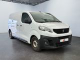the small white van is parked in a large room