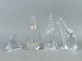 trois figurines d'animaux en verre transparent posées les unes à côté des autres sur une table