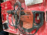 a drill that is attached to a red piece of equipment
