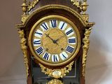 a gold clock with roman numerals on the face