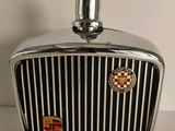 a chrome car hood ornament with a checkered emblem on it