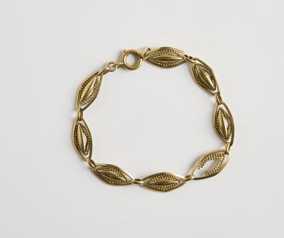 un bracelet plaqué or orné de feuilles sur fond blanc