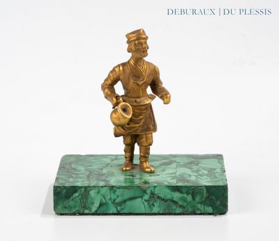 bronze figurine of a man holding a pot on a green marble base