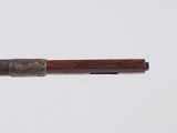 a close up of a pen with a wooden handle on a white surface
