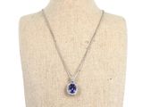 a necklace with a blue sapphire and diamond pendant on a mannequin