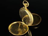 an image of a gold pocket watch on a black surface