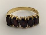 an image of a gold ring with five garnets of garnets