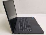a black laptop with a blue keyboard on a white table