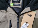 the jacket is tan and black with a tag attached to it