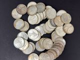 pile of silver coins on a black surface