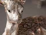 silver deer figurine sitting on top of a table next to a pile of coins