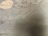 a penny sitting on the ground next to a piece of paper