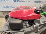a lawn mower with a red engine and a green handle