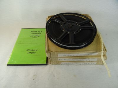 une bobine de film posée sur une boîte à côté d'un livre