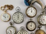 many different types of pocket watches on the table