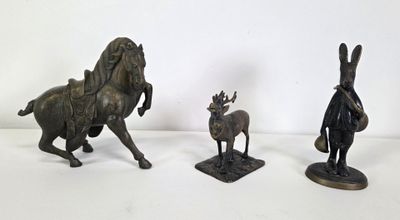 three bronze figurines of a horse, a man, and a deer
