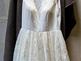 a white dress hanging on a hanger on a wall