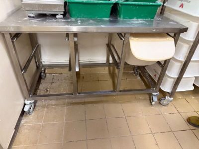 une photo d'une table en acier inoxydable sur laquelle sont posées deux poubelles vertes