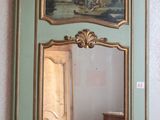 un miroir accroché au mur au-dessus d'un bureau sur lequel se trouve une lampe